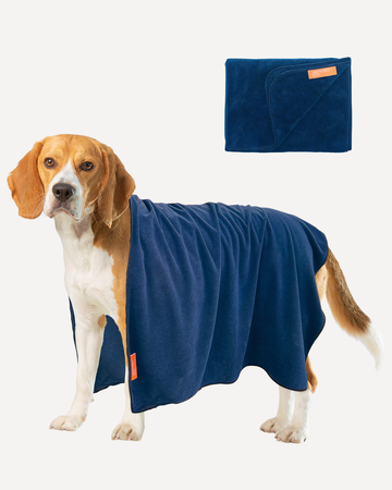 A small to medium-sized dog wearing a dark blue microfiber towel designed for pets, with an additional folded view of the towel displayed next to the dog.